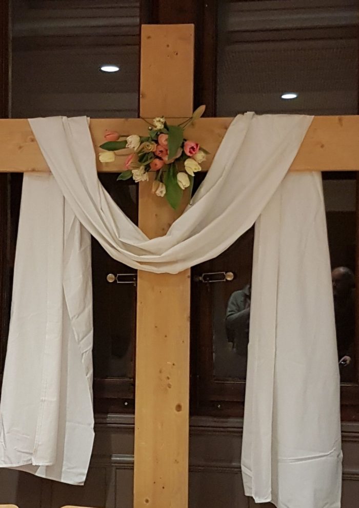 Grande croix en bois décorée avec fleurs et linceul