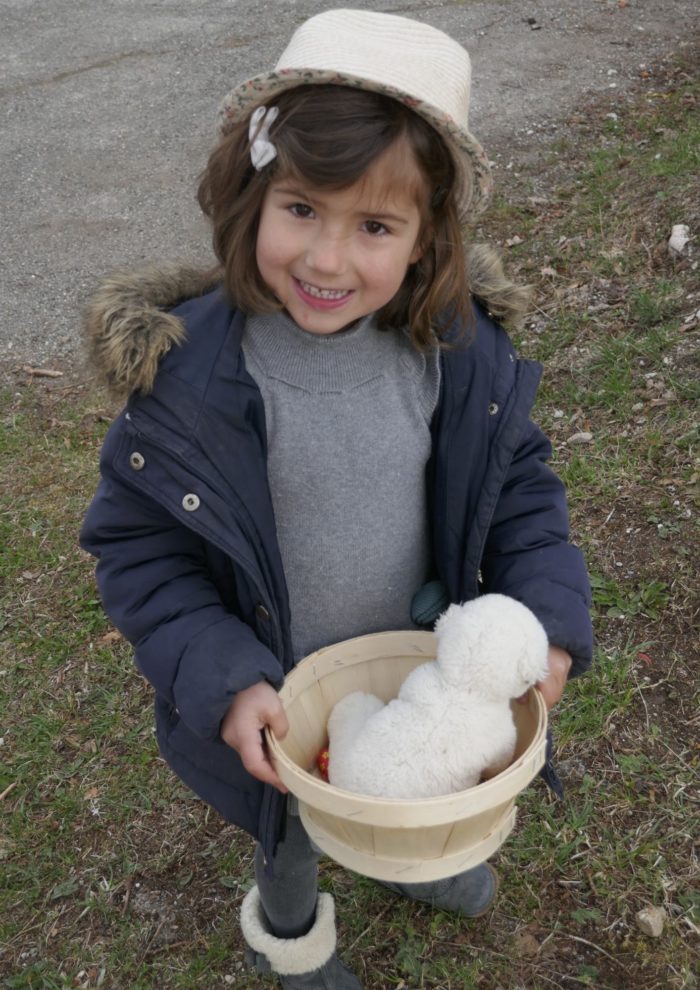 Petite fille faisant la chasse aux oeufs le matin de Pâques